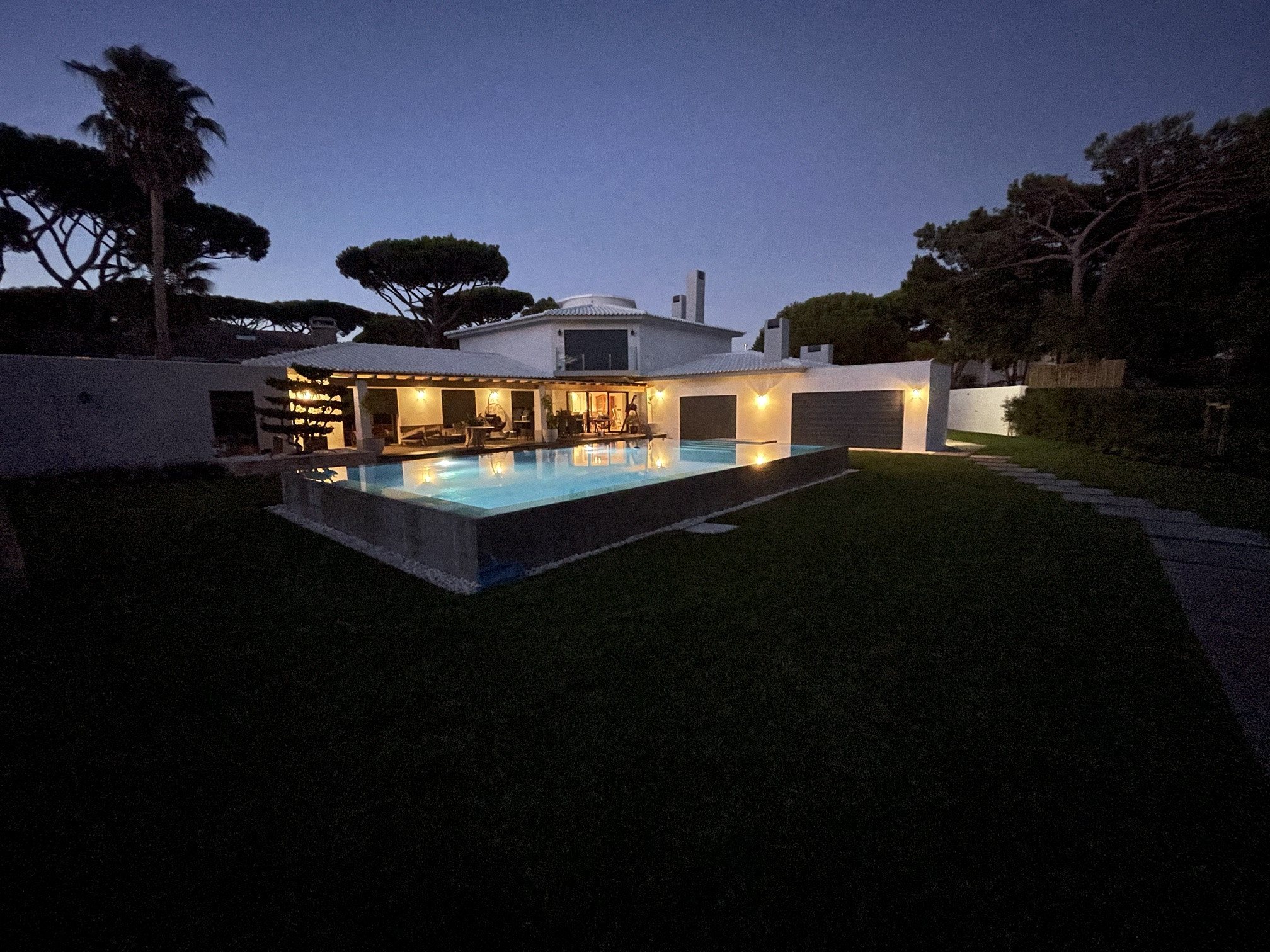 Villa at Quinta da Marinha at dusk, with exterior lighting and pool